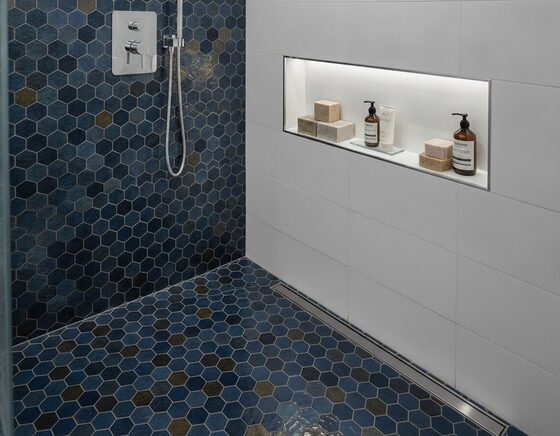 Finished bathroom with feature mosaic floor tiles and a tiled shower niche